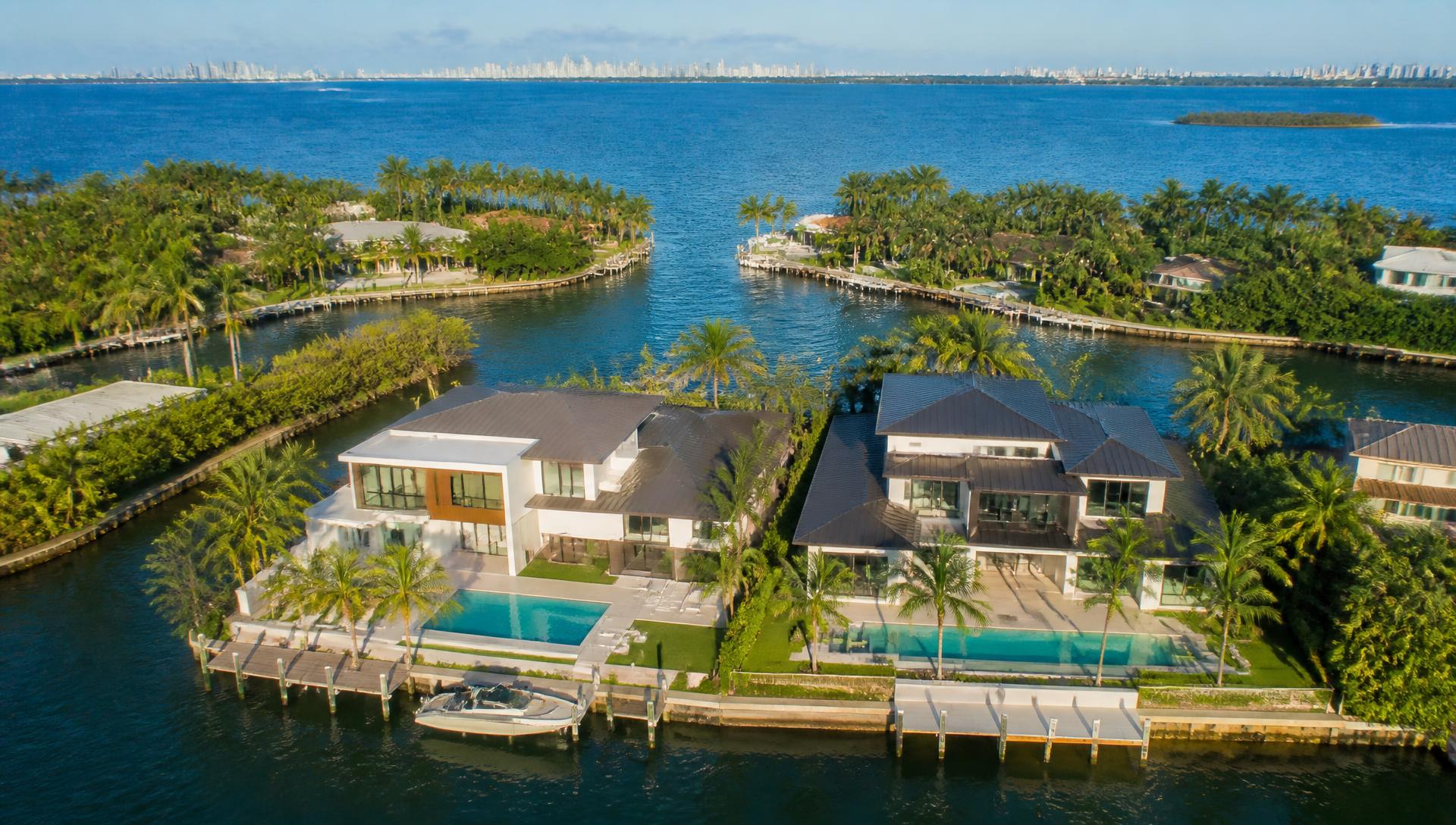 Aerial view of two luxury waterfront residences on a Miami canal